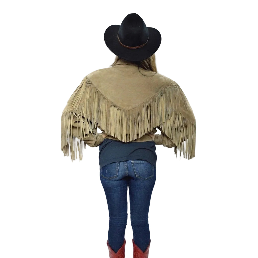 Woman wearing a beige fringe jacket, blue jeans, and red boots on a white background