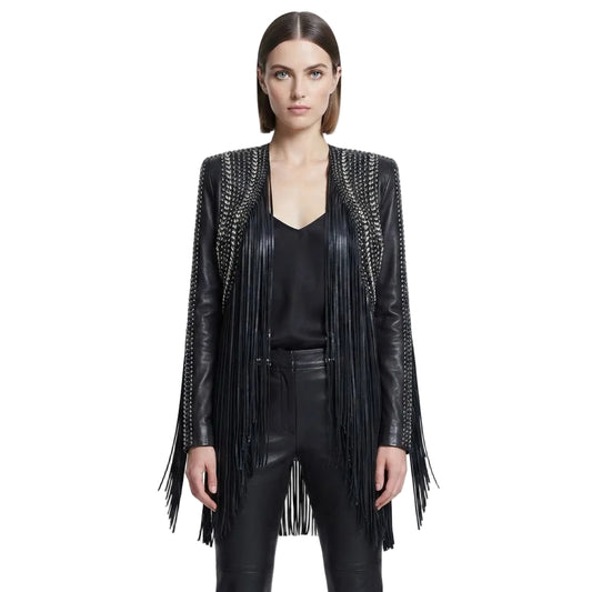 A model wearing a black leather fringe jacket with silver chain detailing on the shoulders, styled over a black top and black leather pants against a white studio background.