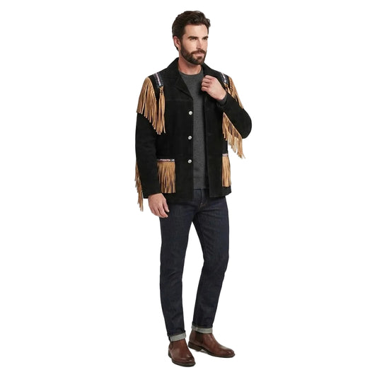 A man modeling a black suede fringe jacket with tan leather fringe, dark gray t-shirt, dark blue jeans, and brown boots against a white studio background.