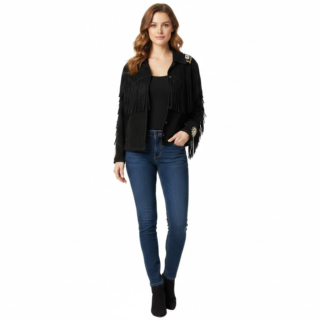 Woman wearing a black fringed jacket, black top, and blue jeans on a white background
